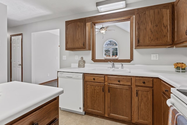 kitchen featuring sink, white appliances, vaulted ceiling, a textured ceiling, and ceiling fan