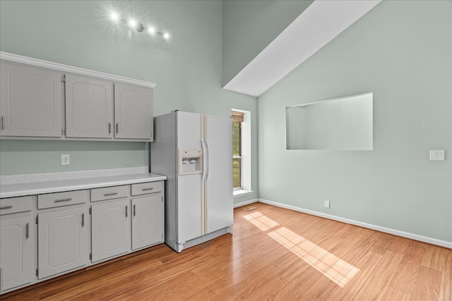 493 Lennox Way, Rocky Face, GA 30740 - kitchen with light wood-type flooring, baseboards, gray cabinetry, light countertops, and white fridge with ice dispenser