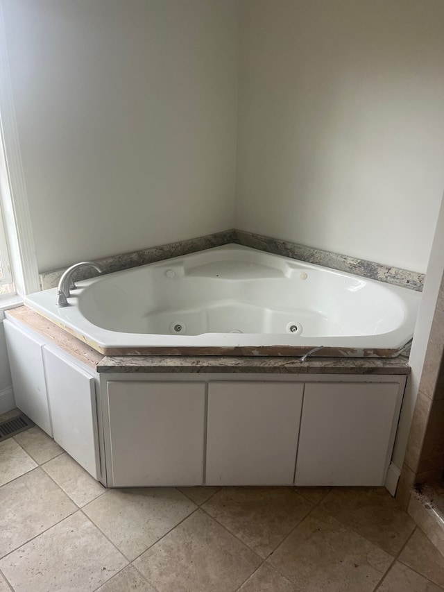 bathroom with a washtub and tile patterned floors