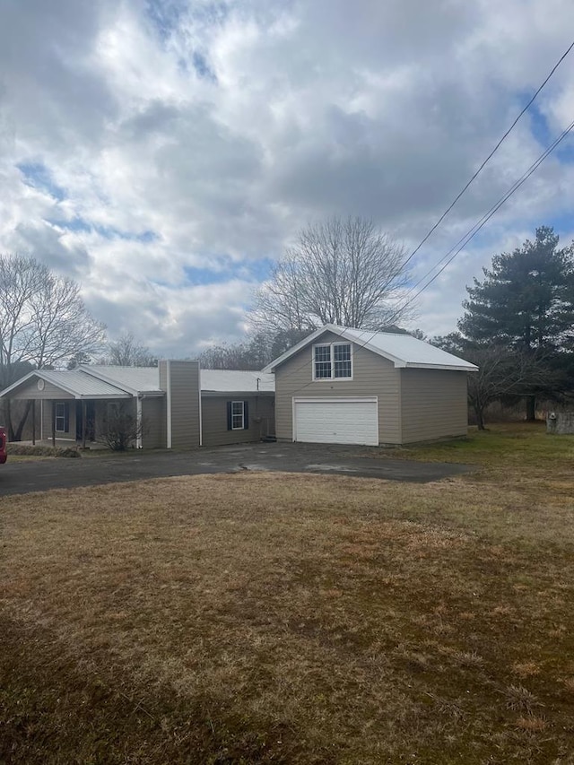 exterior space featuring a garage and a lawn