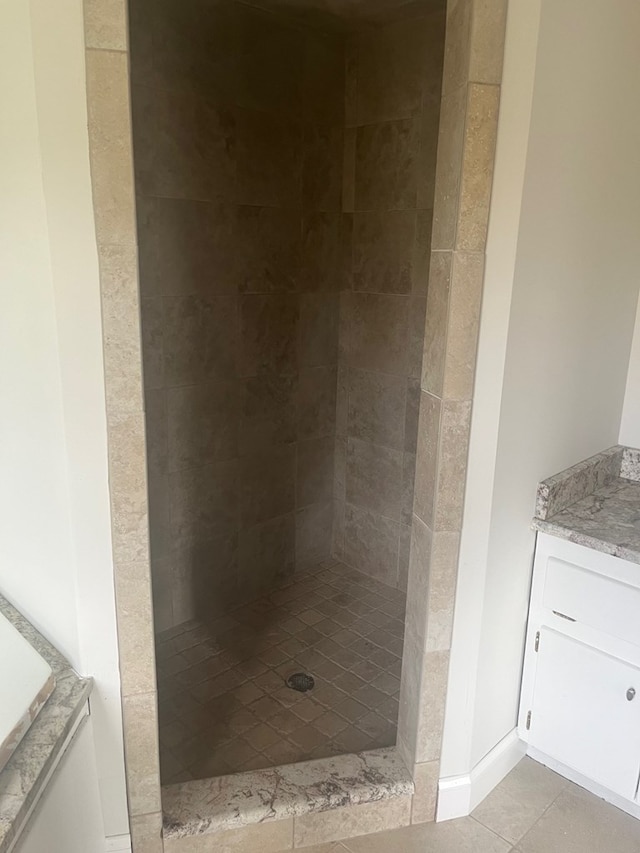 bathroom with vanity, a tile shower, and tile patterned floors