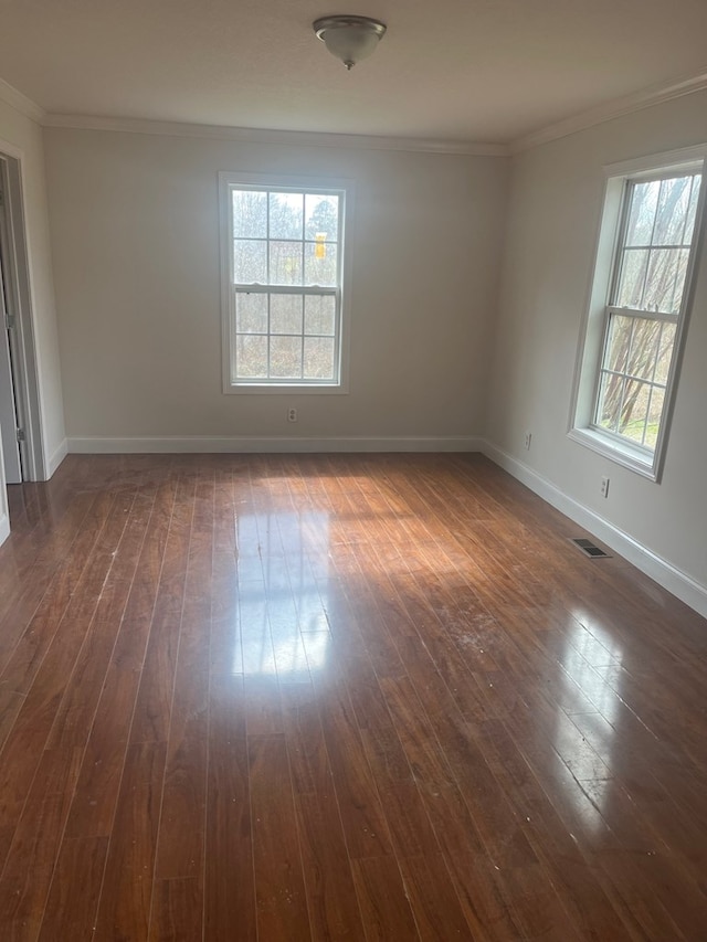 unfurnished room featuring dark wood-type flooring and ornamental molding