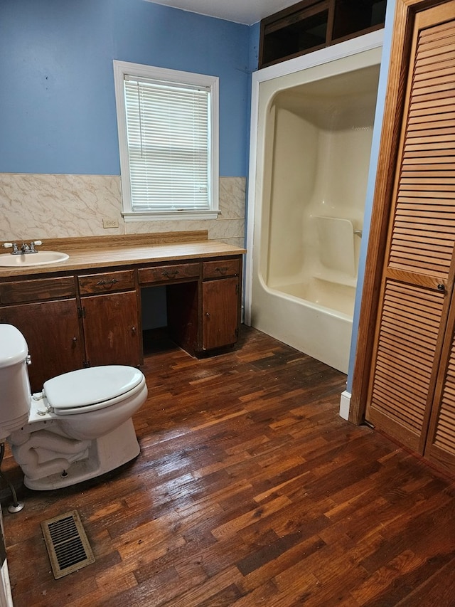 3165 Mcdaniel Station Rd, Adairsville, GA 30103 - bathroom featuring toilet, wood finished floors, a bath, and backsplash