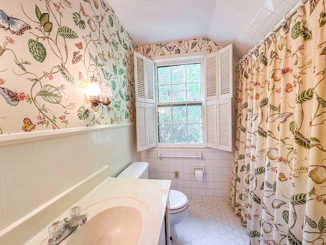 705 Greenwood Dr, Dalton, GA 30720 - bathroom with vanity, wainscoting, lofted ceiling, toilet, and wallpapered walls