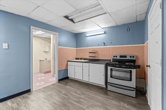 843 Mcafee St, Dalton, GA 30721 - kitchen with electric stove, wood finished floors, a sink, tile walls, and white cabinetry