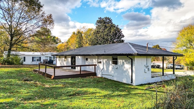 rear view of property featuring a yard and a deck