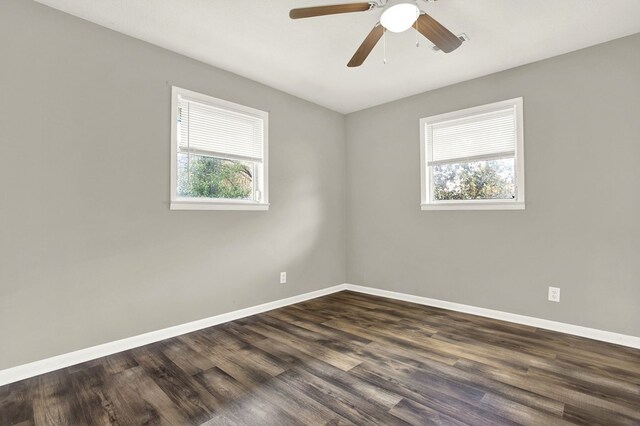 spare room featuring ceiling fan, dark wood-type flooring, and a healthy amount of sunlight