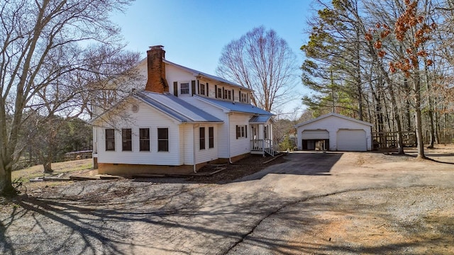 view of front of home with a garage and an outdoor structure