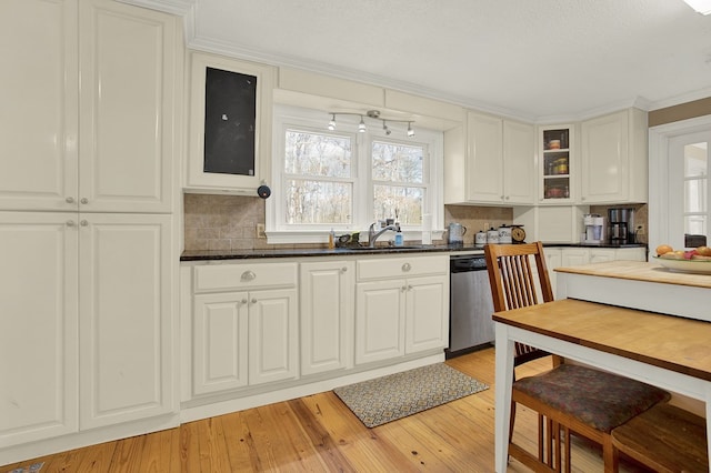 kitchen featuring sink, tasteful backsplash, light wood-type flooring, stainless steel dishwasher, and white cabinets