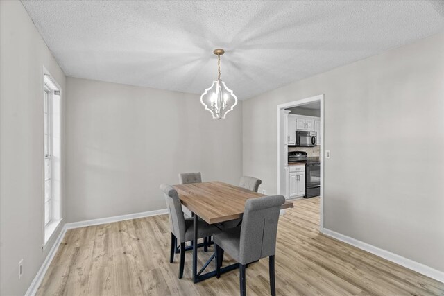 353 Diamond Way, Chatsworth, GA 30705 - dining area featuring light wood-type flooring, a chandelier, healthy amount of natural light, and a textured ceiling