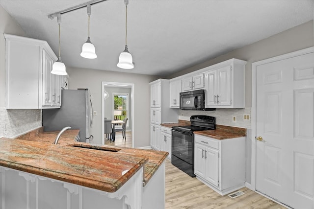 353 Diamond Way, Chatsworth, GA 30705 - kitchen with black appliances, a peninsula, backsplash, and white cabinets