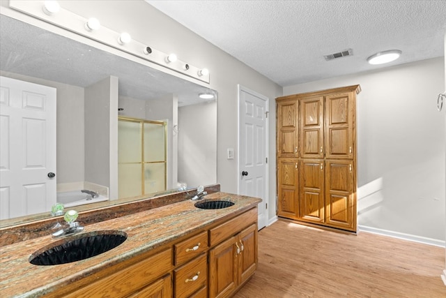 353 Diamond Way, Chatsworth, GA 30705 - full bath featuring a stall shower, a garden tub, a textured ceiling, wood finished floors, and double vanity