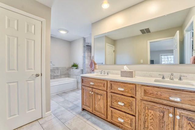 bathroom featuring tile patterned flooring, vanity, and a tub