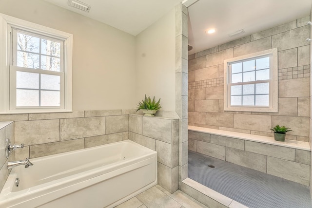 bathroom featuring tile patterned flooring and shower with separate bathtub