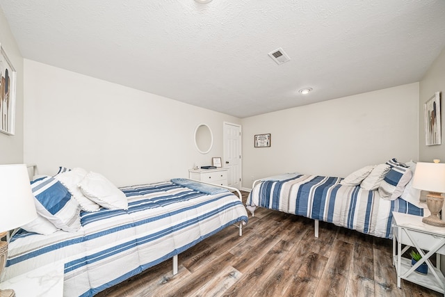 bedroom featuring visible vents and wood finished floors