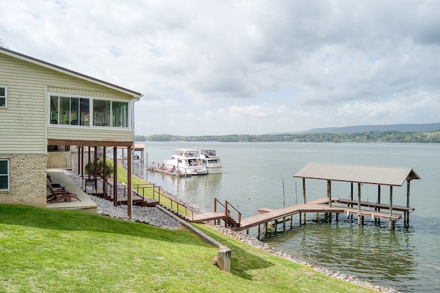 dock area featuring boat lift, a yard, and a water view