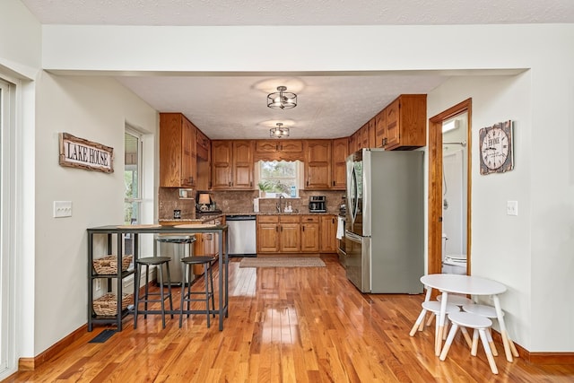 kitchen featuring light wood-style floors, stainless steel appliances, and a sink