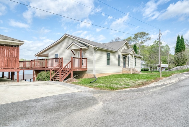 view of front of house featuring a wooden deck, a front lawn, and metal roof