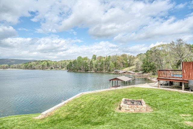 exterior space with a wooded view and an outdoor fire pit