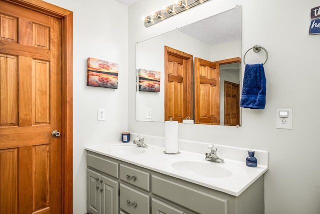 full bathroom with double vanity and a sink