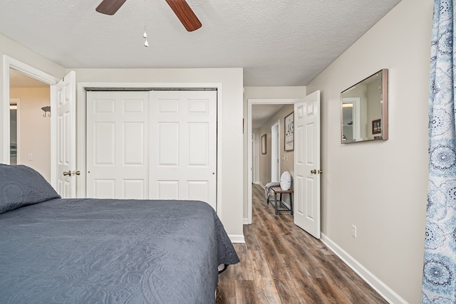 bedroom with a closet, a ceiling fan, baseboards, and dark wood-style flooring