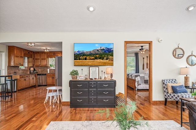 living room with baseboards, a wealth of natural light, and light wood-type flooring