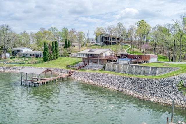 view of dock featuring a lawn, a deck with water view, and boat lift