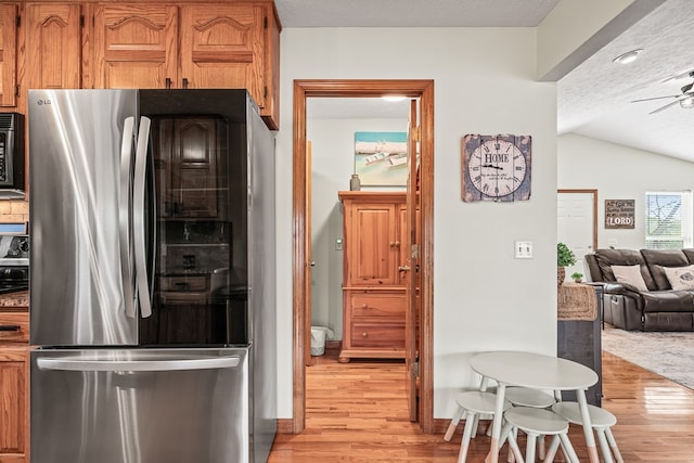 kitchen with black microwave, ceiling fan, light wood-style flooring, and smart refrigerator