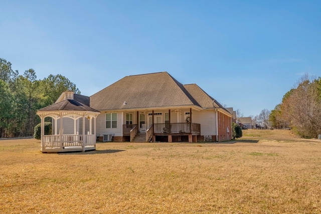 back of property featuring cooling unit, a gazebo, a ceiling fan, and a yard