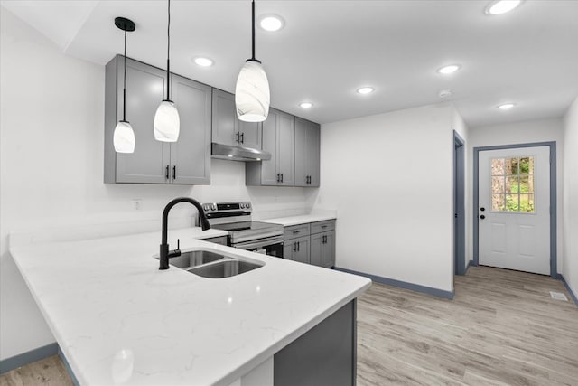 409 Van Buren Dr, Dalton, GA 30721 - kitchen with stainless steel electric range, under cabinet range hood, gray cabinets, a peninsula, and light wood finished floors