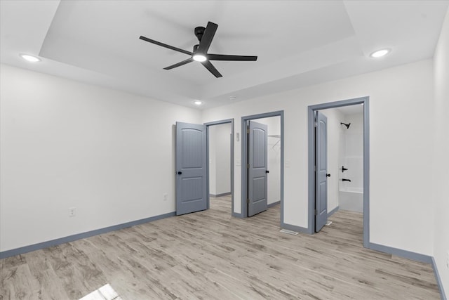 409 Van Buren Dr, Dalton, GA 30721 - unfurnished bedroom with a tray ceiling, light wood-style flooring, recessed lighting, ensuite bath, and ceiling fan