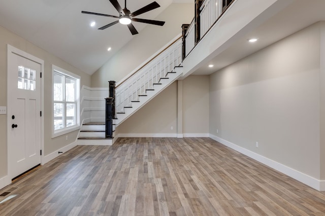 entrance foyer featuring ceiling fan, light hardwood / wood-style floors, and a high ceiling