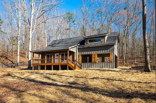 view of front of house featuring covered porch, board and batten siding, and stairs