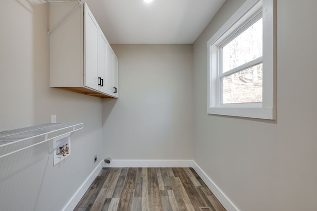 clothes washing area featuring cabinets, washer hookup, and dark hardwood / wood-style floors