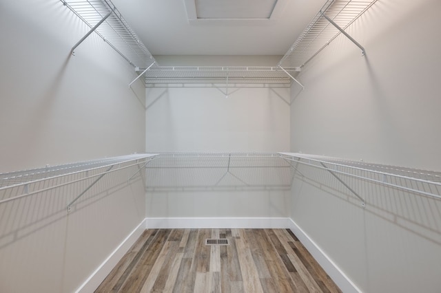 spacious closet featuring visible vents and wood finished floors