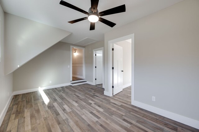 bonus room featuring attic access, light wood-type flooring, and baseboards