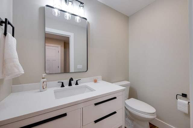 half bathroom with toilet and vanity