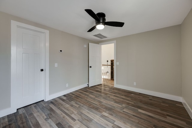 unfurnished bedroom featuring ceiling fan, dark wood-type flooring, visible vents, and baseboards