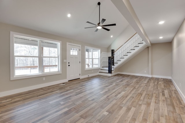 unfurnished living room featuring lofted ceiling, light hardwood / wood-style floors, and ceiling fan