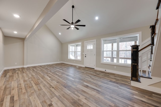 unfurnished living room featuring vaulted ceiling, ceiling fan, and light wood-type flooring