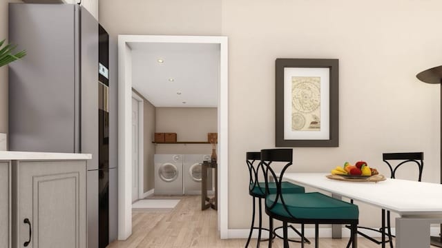 dining area featuring light wood-type flooring and washer and clothes dryer