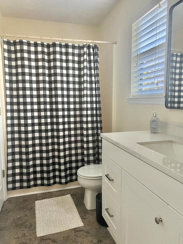 bathroom featuring vanity, curtained shower, a textured ceiling, and toilet