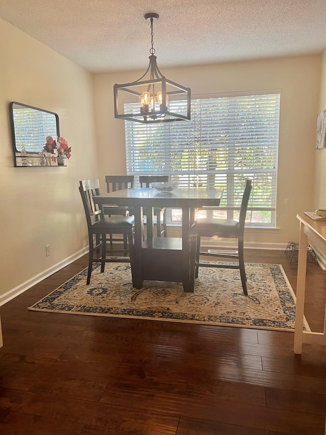 dining area featuring hardwood / wood-style floors, a notable chandelier, and a textured ceiling