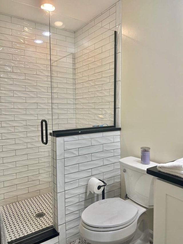 bathroom with vanity, a shower with door, and toilet