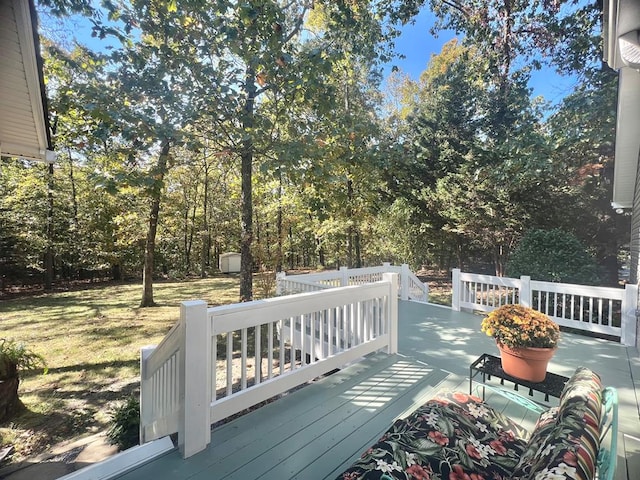 deck featuring a lawn and a storage unit