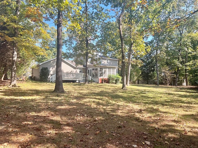 view of yard featuring a sunroom and a deck