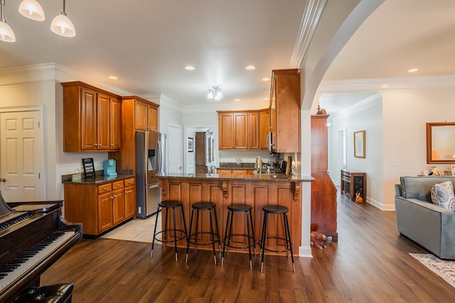 3034 Highland Cir, Rocky Face, GA 30740 - kitchen featuring a peninsula, stainless steel appliances, arched walkways, and light wood-type flooring