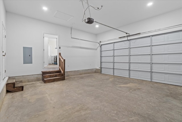 garage featuring electric panel, a garage door opener, and recessed lighting