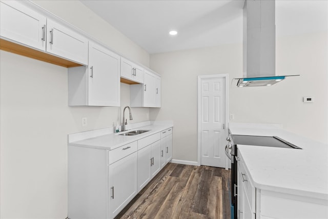 kitchen featuring dark wood-type flooring, stainless steel electric stove, white cabinetry, wall chimney exhaust hood, and a sink