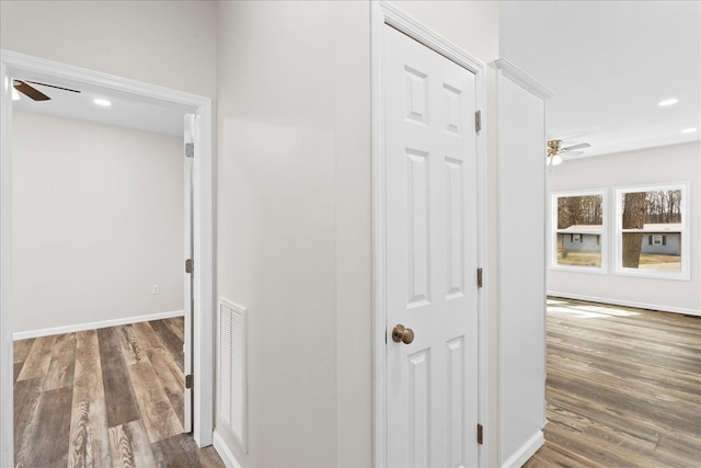 hallway featuring recessed lighting, visible vents, baseboards, and wood finished floors